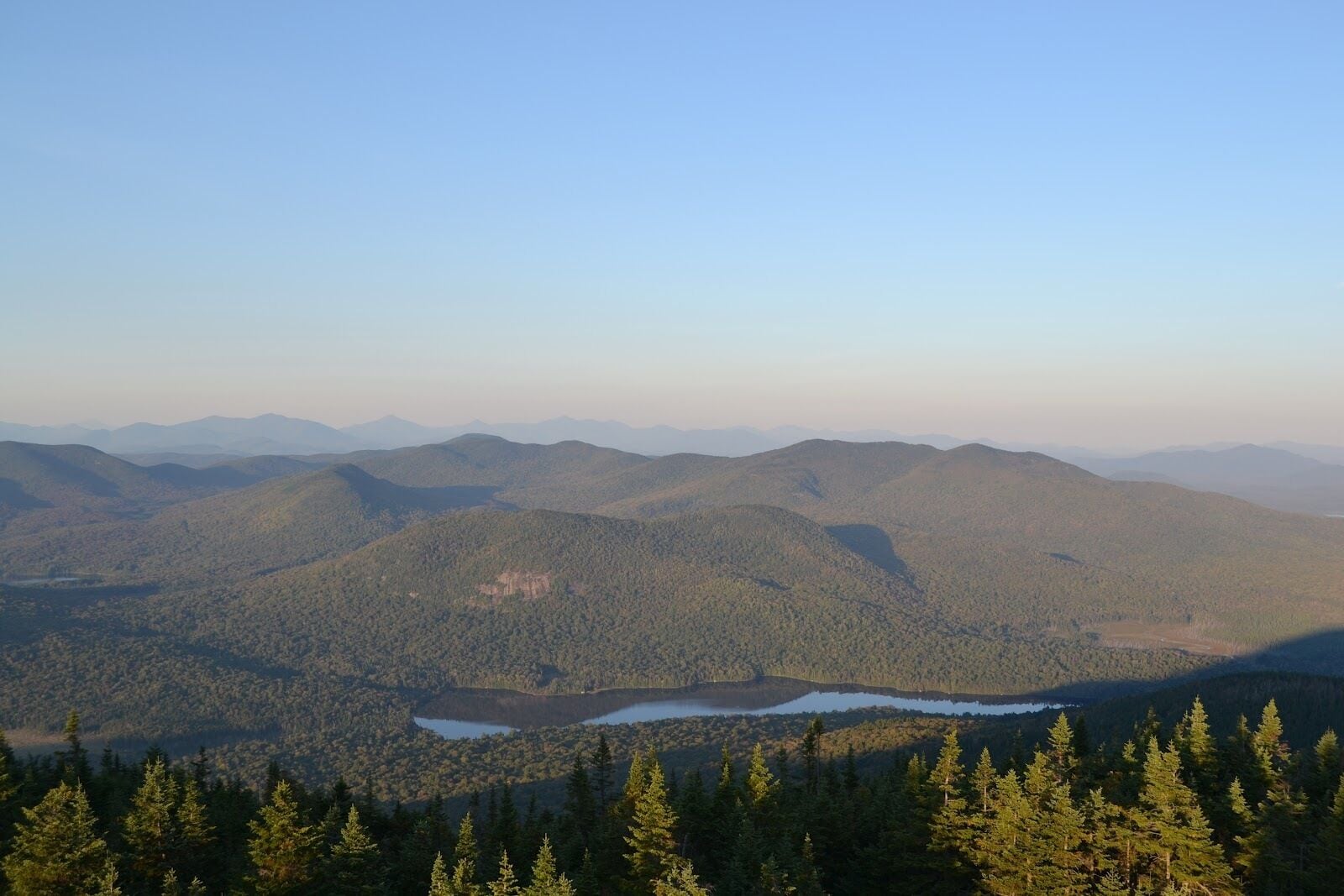 Un paysage montagneux, avec de vastes forêts et un lac.