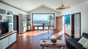 Een ruime woonkamer met een groot raam en uitzicht op de stad.