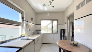 Une cuisine moderne avec une table à manger, une fenêtre et un ventilateur de plafond.