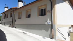 Un bâtiment à la façade beige, doté de nombreuses fenêtres et d’une enseigne indiquant « Calle Del Olmo Kalea ».