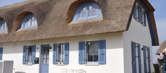 Olkikattoinen mökki Wismarin lahdella