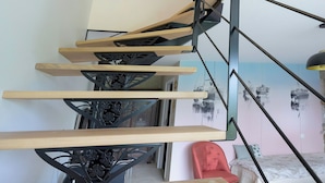 A modern staircase with a black metal railing and wooden steps. - Quiet and seaside in charming house 3000 m2 park (Créhen)