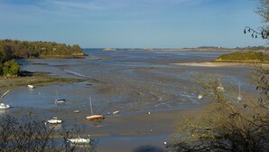 A coastal landscape with boats on a sandy beach and a forested area in the background. - Quiet and seaside in charming house 3000 m2 park (Créhen)