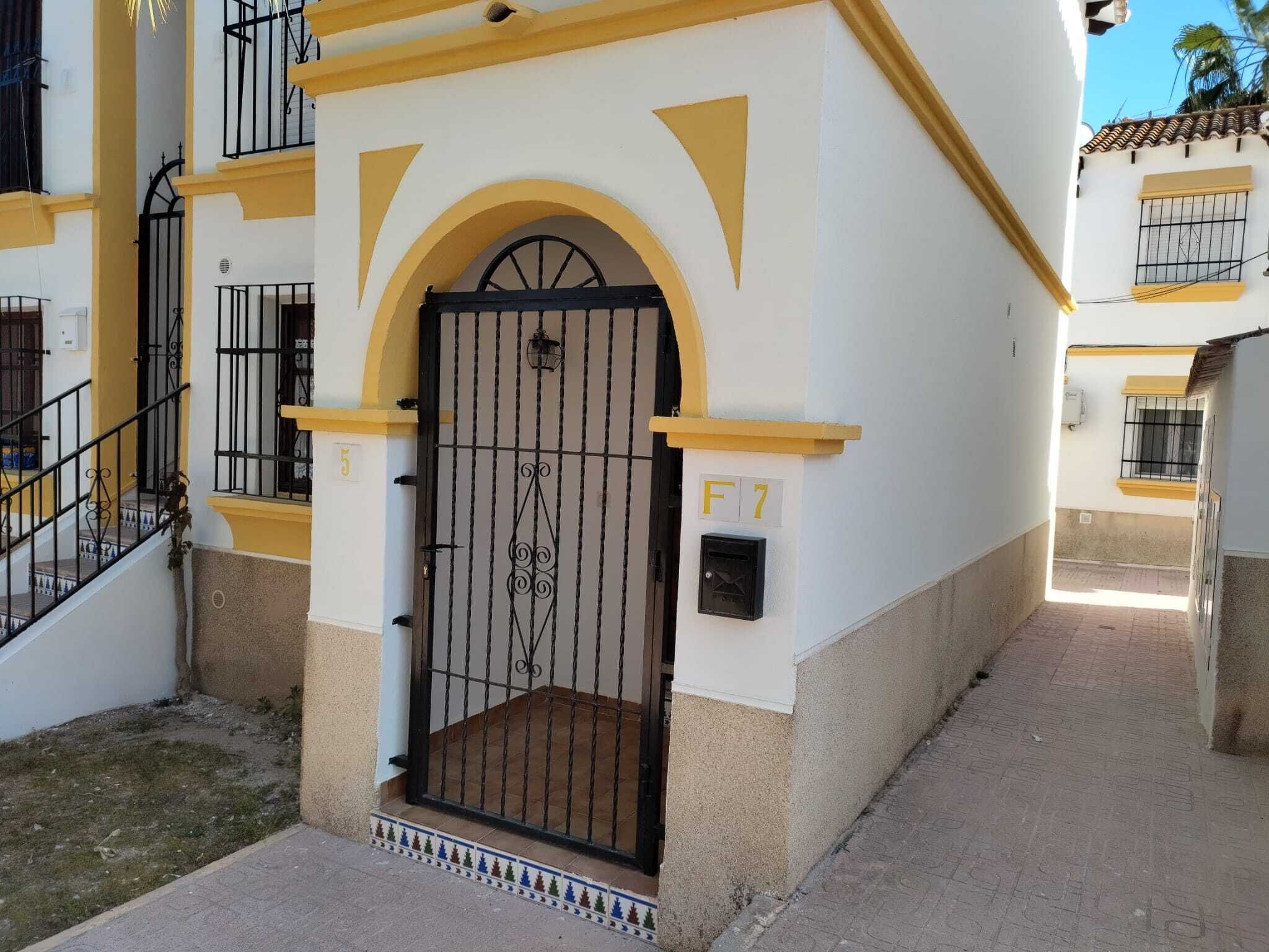 A building with a gated entrance, a staircase, and a mailbox labeled 'F7'.