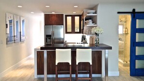A modern kitchen with a central island, stainless steel appliances, and wooden cabinetry.