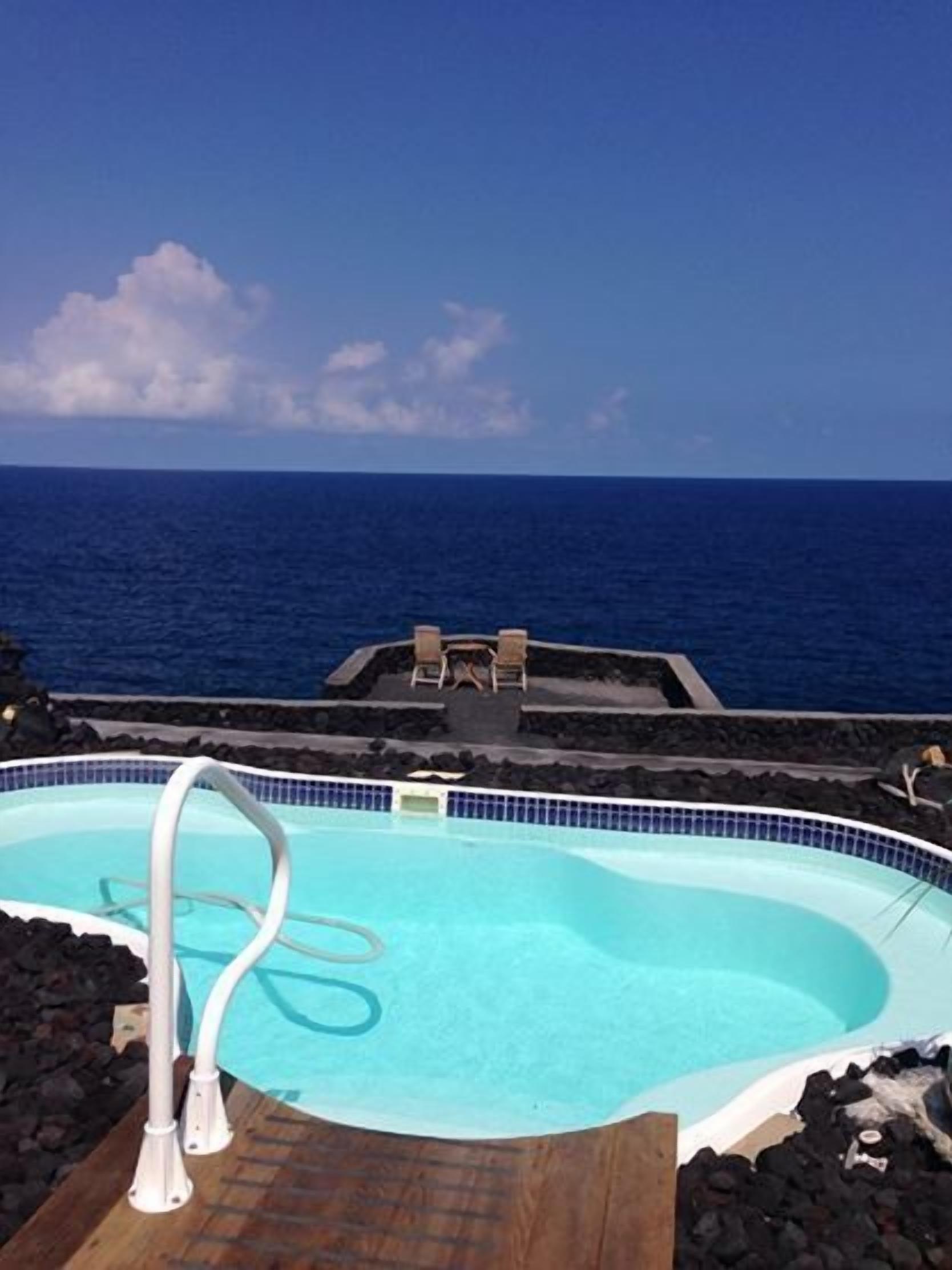 A swimming pool with a clear view of the ocean.