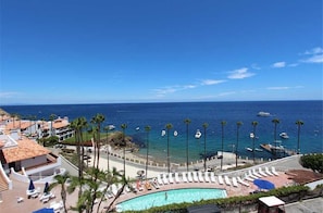 Un complexe hôtelier doté d’une piscine, d’une plage et offrant une vue sur l’océan.