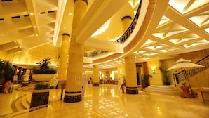 A spacious lobby with a grand staircase, marble columns, and a high ceiling with geometric patterns. - Palm Beach Resort&Spa Sanya (Sanya)
