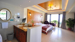 A hotel room with a large bed, a bathroom with a double sink, a mirror, and a ceiling light fixture. - Palm Beach Resort&Spa Sanya (Sanya)