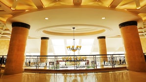 A spacious lobby with high ceilings, large columns, and a central chandelier. - Palm Beach Resort&Spa Sanya (Sanya)