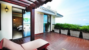 A modern outdoor patio with a wooden pergola, a seating area with cushioned chairs, and a view of a coastal landscape. - Palm Beach Resort&Spa Sanya (Sanya)