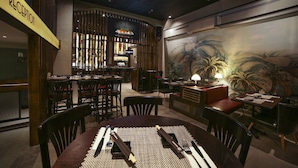 A restaurant with a reception area, bar, and dining tables with chairs. - Diana Hotel (Haifa)