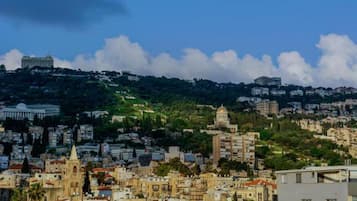 A cityscape with a prominent church, residential buildings, and a hill with scattered structures.