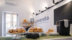 A breakfast buffet with pastries, coffee mugs, and a coffee machine. - B&B Università (Naples)