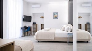 A modern hotel room with a large bed, a desk with a chair, a TV, and a small table. - B&B Università (Naples)