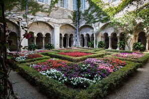 A courtyard with a central flower garden and arched walkways. - "Casa Dora" - sleeps 4, 2bed 2bath self catering Apartment heart of Provence (Rognonas)