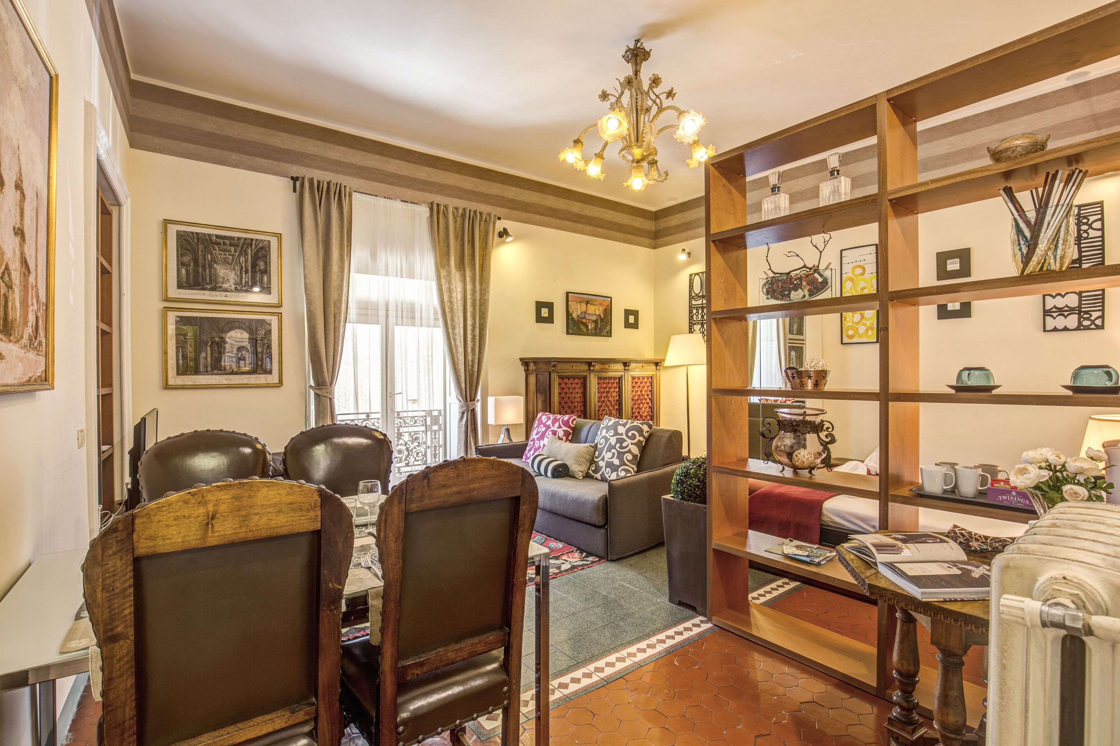 Un salon chaleureux avec une cheminée, un coin repas avec une table et des chaises, et une bibliothèque remplie d’objets décoratifs.