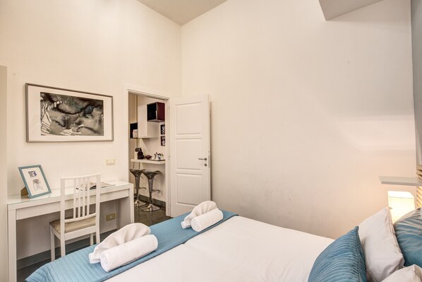 A hotel room with a bed, a desk, a chair, and a door leading to a bathroom. - Rome Supercentral: between Piazza Navona and Campo dè Fiori (Roma)