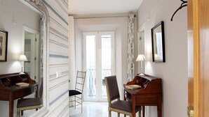 A hallway with a grand mirror, a piano, and a chair. - Celinda Terrace. 2 bedrooms, 2 bathrooms, private terrace (Seville)