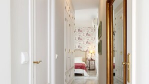 A hallway leading to a bedroom with a bed, a nightstand, and a lamp. - Celinda Terrace. 2 bedrooms, 2 bathrooms, private terrace (Seville)