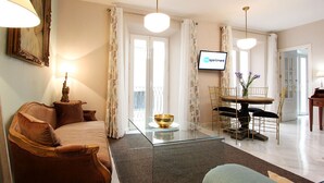 A modern living room with a sofa, a glass coffee table, a dining table with chairs, and a television displaying 'vega apartment'. - Celinda Terrace. 2 bedrooms, 2 bathrooms, private terrace (Seville)