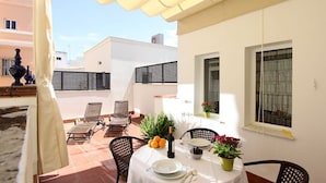 A terrace with a table set for two, outdoor chairs, potted plants, and a bottle of wine. - Celinda Terrace. 2 bedrooms, 2 bathrooms, private terrace (Seville)