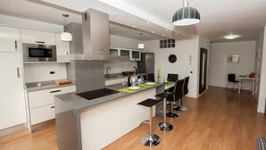 A modern kitchen with a central island, stainless steel appliances, and bar stools. - BEST AREA, CITY CENTER, PLAZA DEL CHARCO, IDEAL FOR FAMILIES (Puerto de la Cruz)