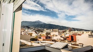 A cityscape with a mountain in the background, viewed from a balcony with a clear sky. - BEST AREA, CITY CENTER, PLAZA DEL CHARCO, IDEAL FOR FAMILIES (Puerto de la Cruz)