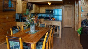 L’intérieur d’une cabane en bois comprend un coin repas, une cuisine et une chambre à coucher située en mezzanine.
