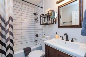 Bathtub, hair dryer, towels, shampoo
