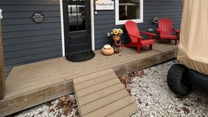 A dark wooden house with a porch, a black door, and a sign that reads "Comfort Life." - 15% Fall Special! Lake Luxury: 6BR/6BA w/ Private Dock| Quiet Cove| (LaFollette)