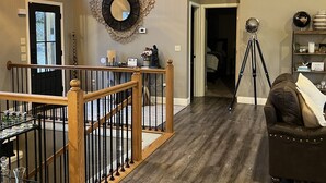 A spacious living area with a wooden ceiling, a staircase with a railing, and a large mirror on the wall. - 15% Fall Special! Lake Luxury: 6BR/6BA w/ Private Dock| Quiet Cove| (LaFollette)