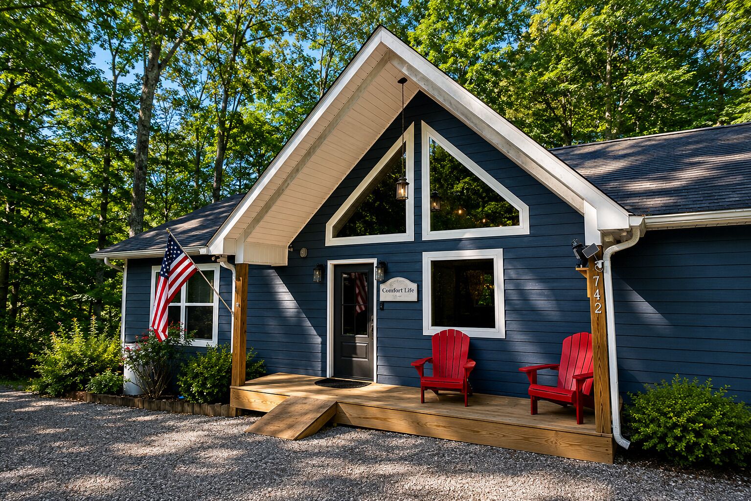 Un bâtiment à deux étages doté d’un porche, de deux fauteuils Adirondack rouges et d’un drapeau américain.
