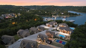 A residential area with houses, a swimming pool, and a dock with boats. - Lakeview Retreat with Pool, Pickleball Court, Boat Slip, Game Room and Hot Tub (Branson)