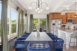 A modern kitchen with wooden cabinets, a stainless steel refrigerator, and a built-in microwave.