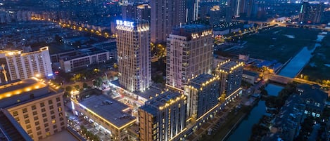 A high-rise building complex with multiple floors, surrounded by other buildings and a river.