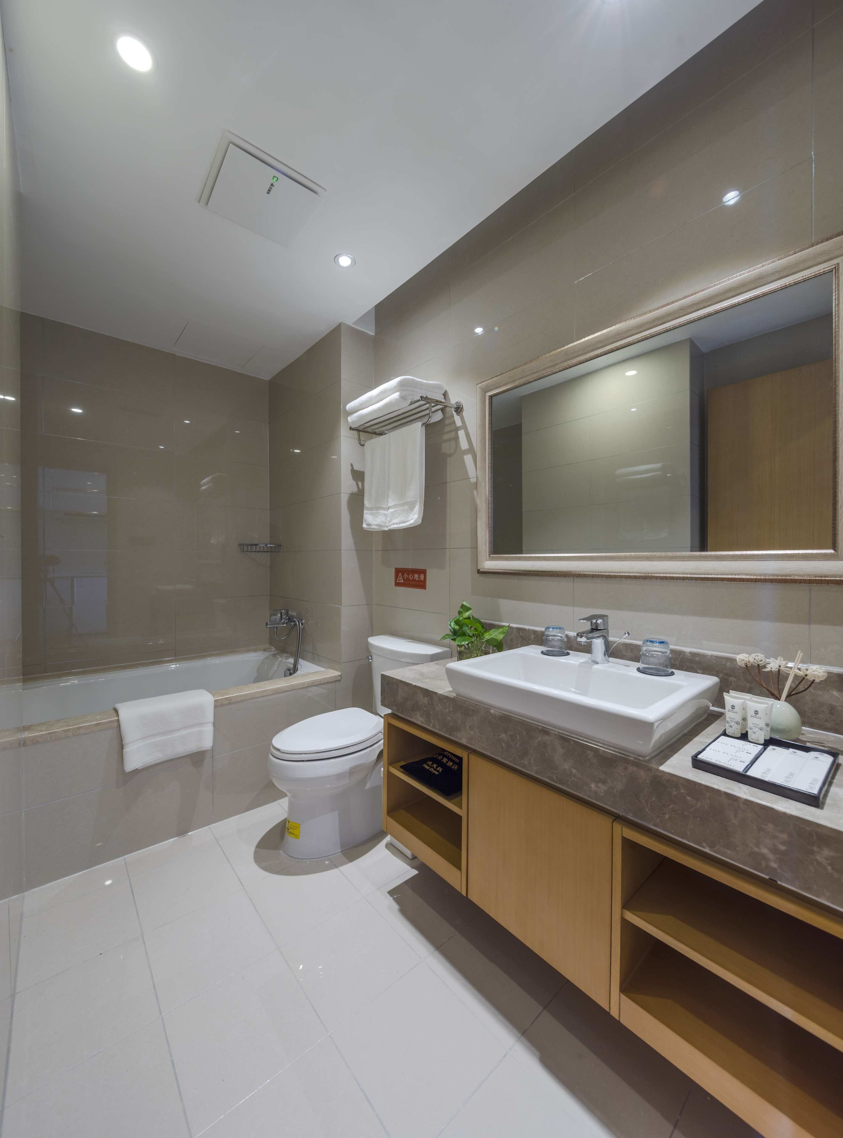 A modern bathroom with a bathtub, toilet, and sink.