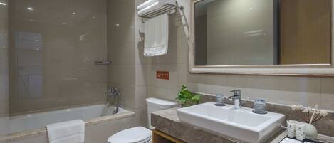 A modern bathroom with a bathtub, toilet, and sink.