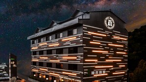 A modern hotel with a starry night sky view, featuring horizontal lighting accents and a prominent logo. - Alishan Shermuh Int' Tourist Hotel (Alishan)