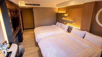 A hotel room with two beds, a desk with a chair, and a TV.