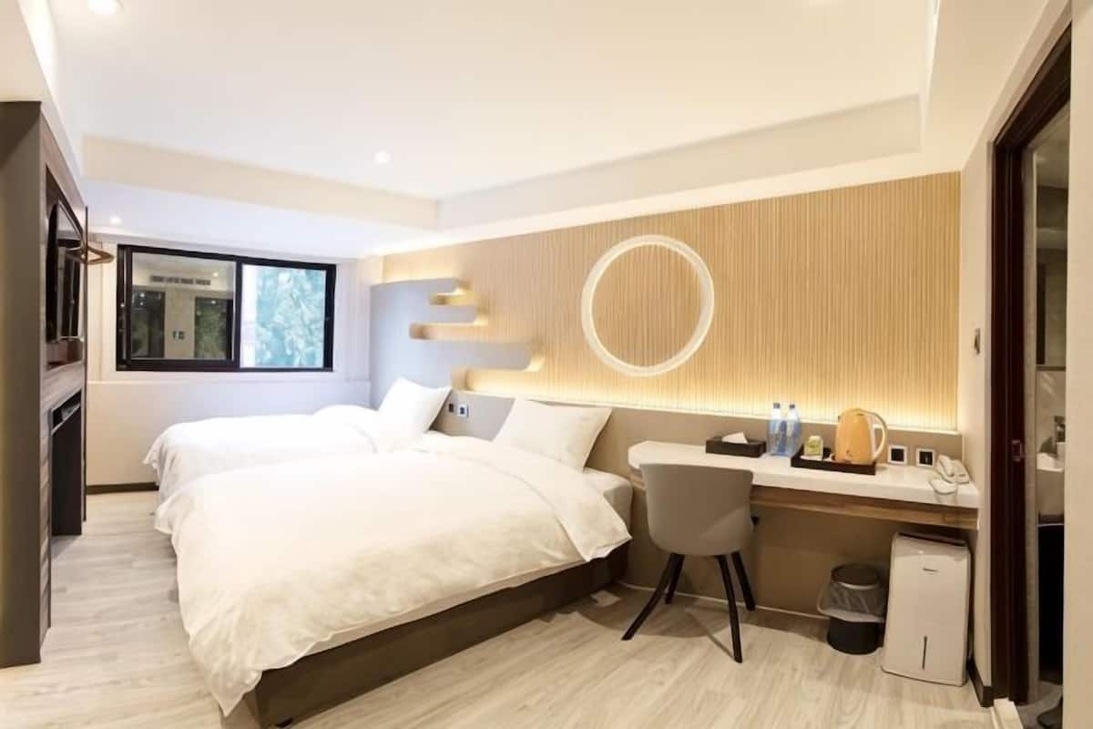 Ett modernt hotellrum med en säng, ett skrivbord och utsikt över omgivningarna.