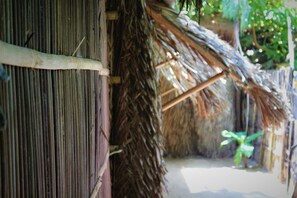 A thatched roof structure with vertical bamboo walls. - Under the coconut tree - Hostel (Da Nang)