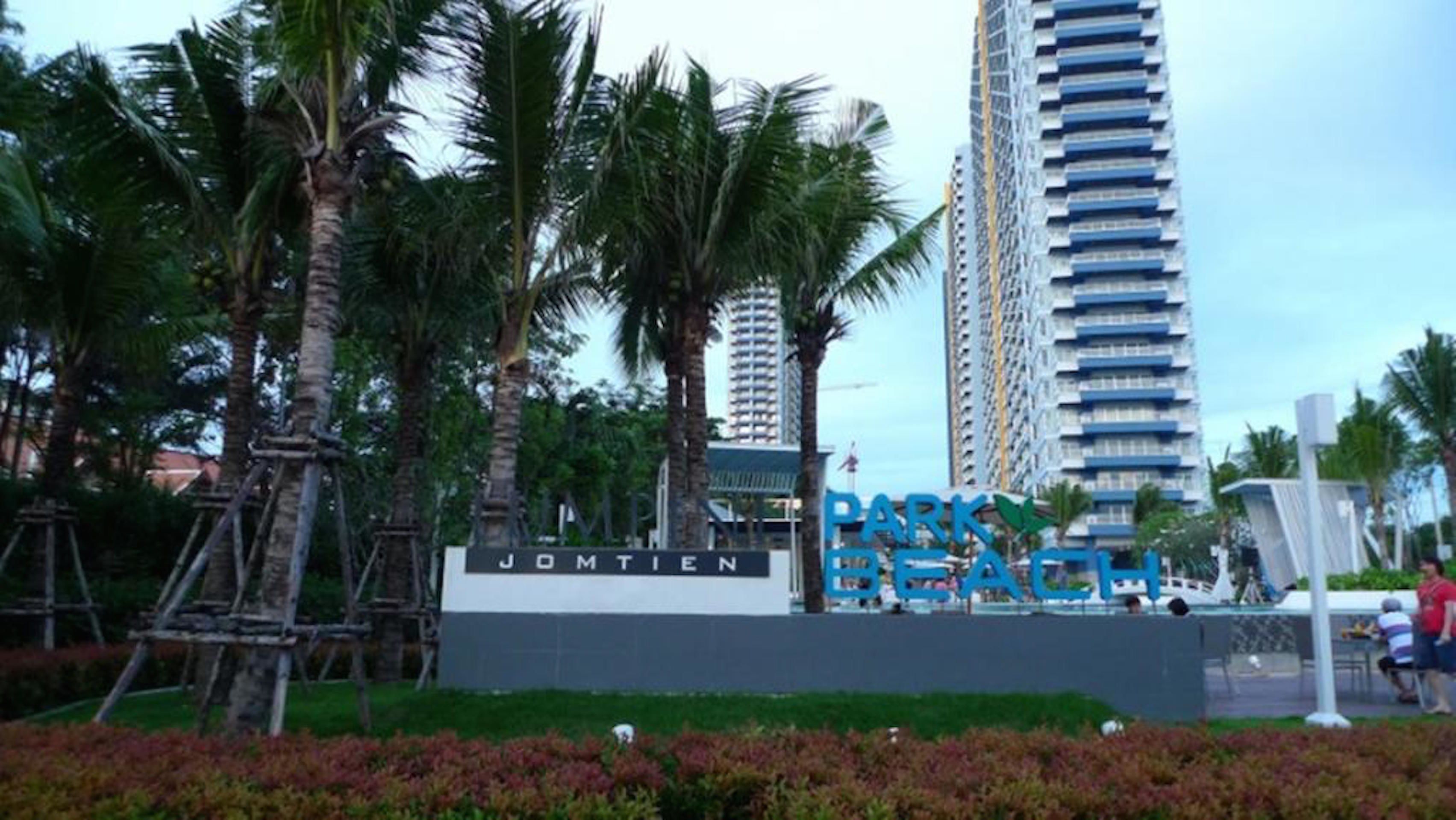 Señal de Park Beach, con palmeras y edificios modernos al fondo.