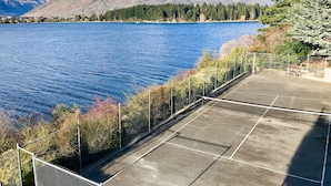A tennis court with a view of a lake and mountains. - Amazing Queenstown Guesthouse (Queenstown)