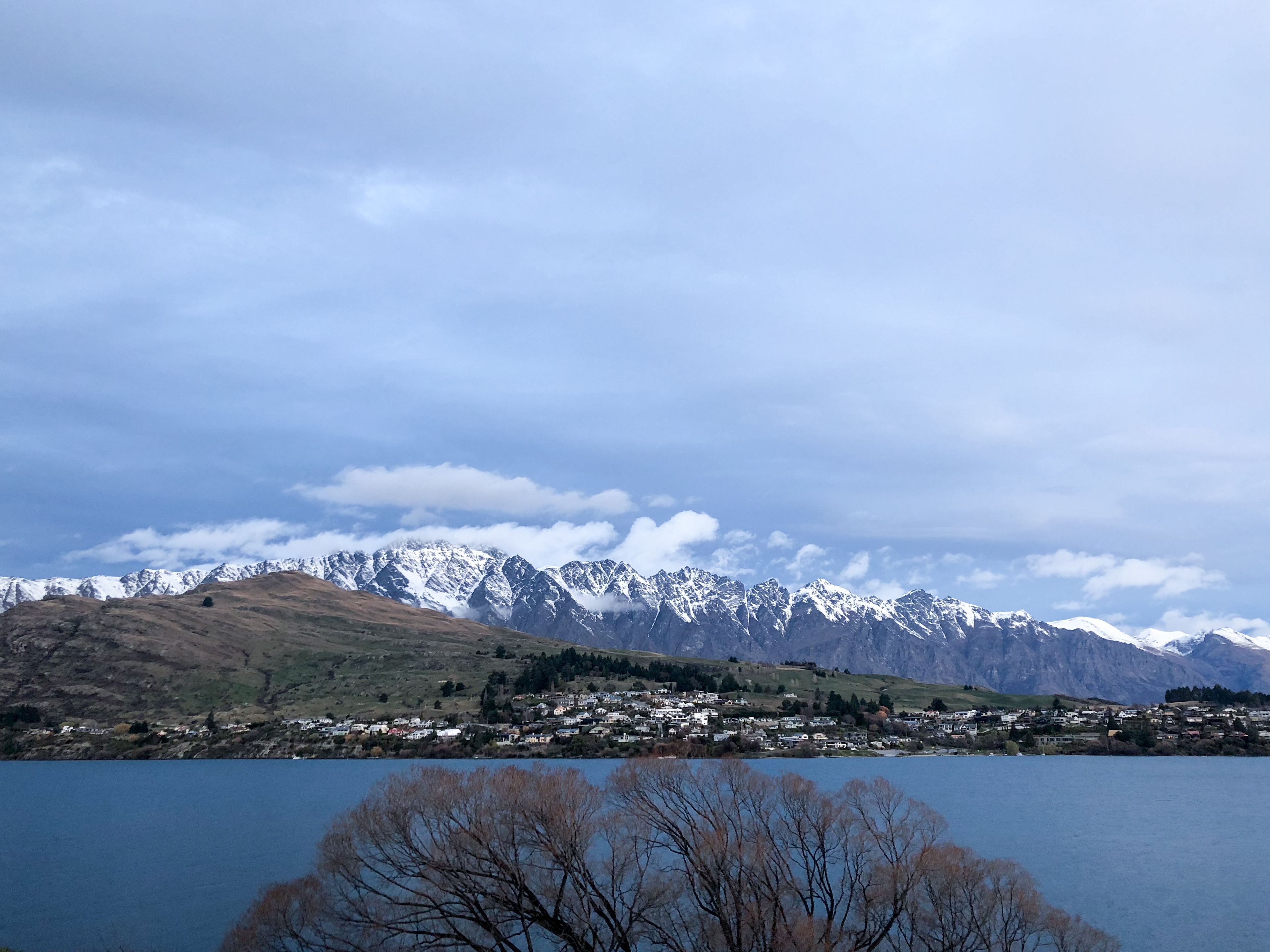 A mountainous landscape with a town by a lake.