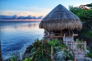 A thatched-roof hut with a wooden deck leading to a sign reading "Authorized Diving Only." - Birdland Beach Club (Bolinao)