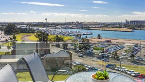 A marina with boats, a parking lot, and a view of the cityscape. - Astra Apartments Newcastle West (Newcastle West)