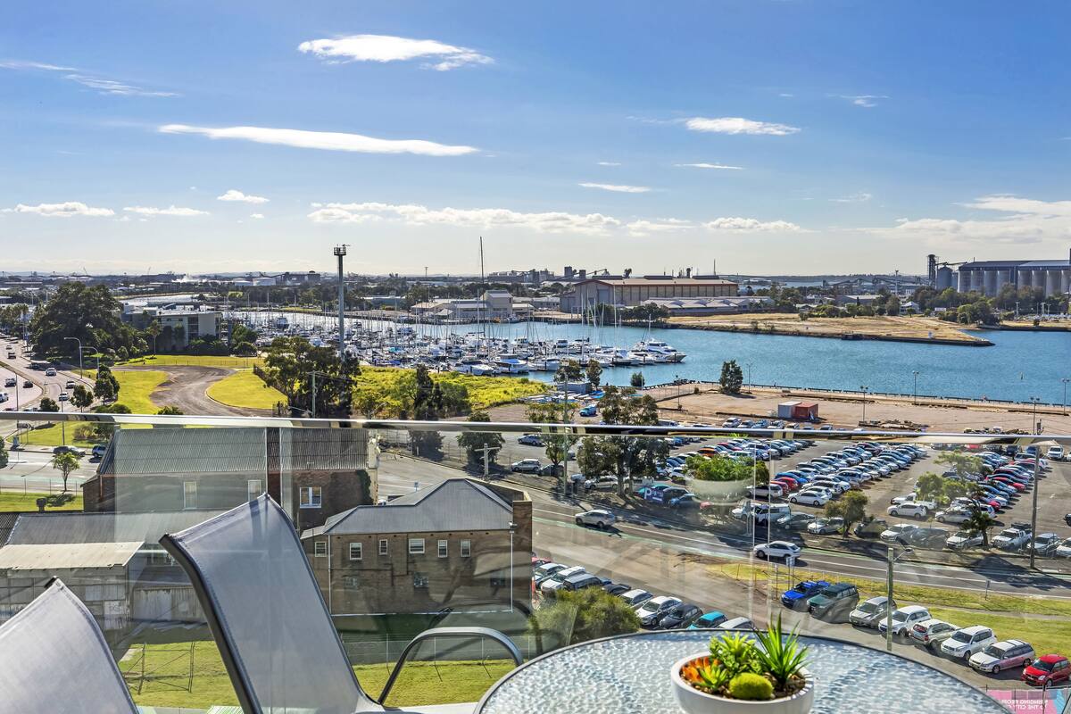 A marina with boats, a parking lot, and a view of the cityscape.