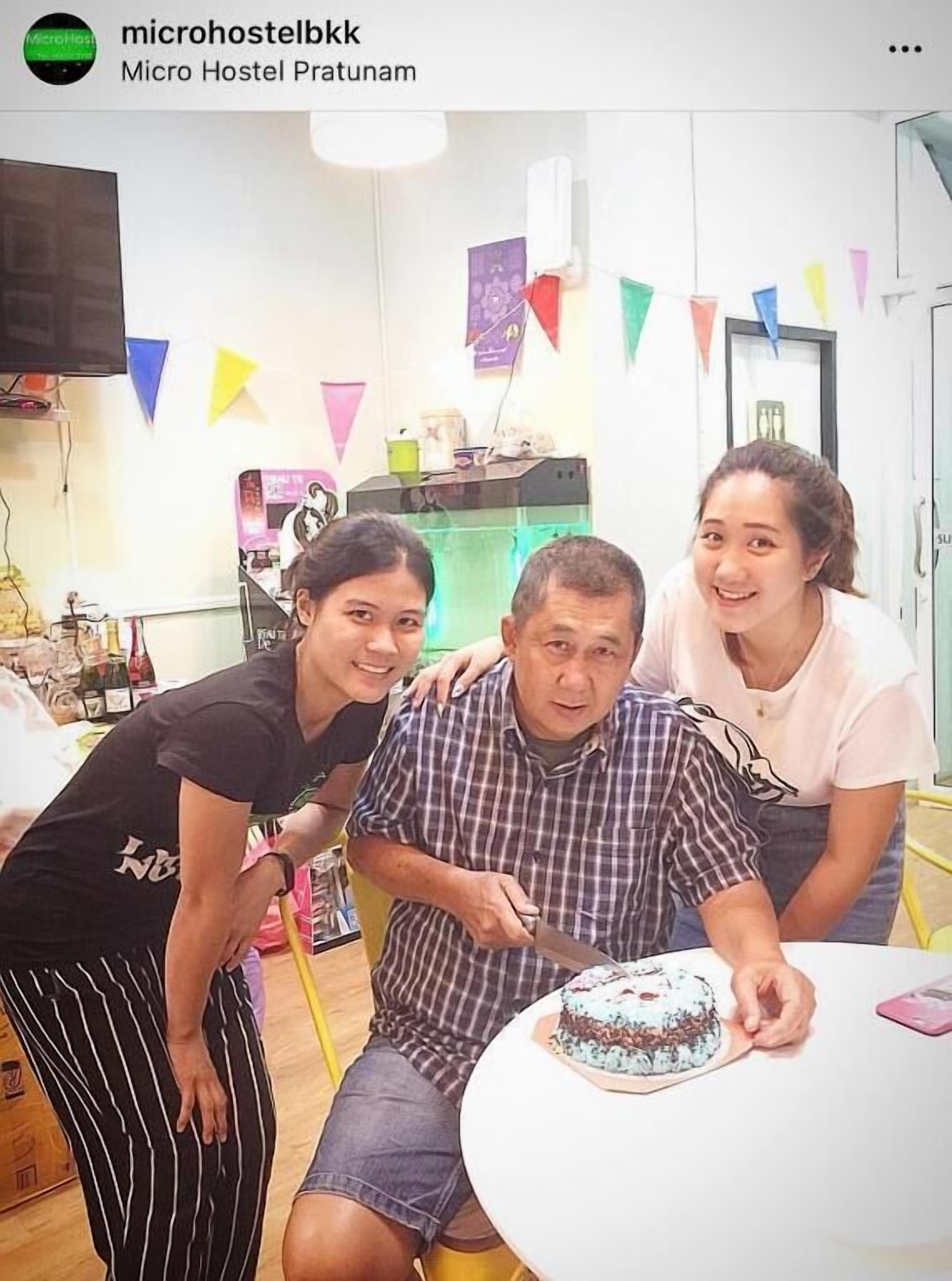 A room with a white table, a cake, and colorful triangular flags.