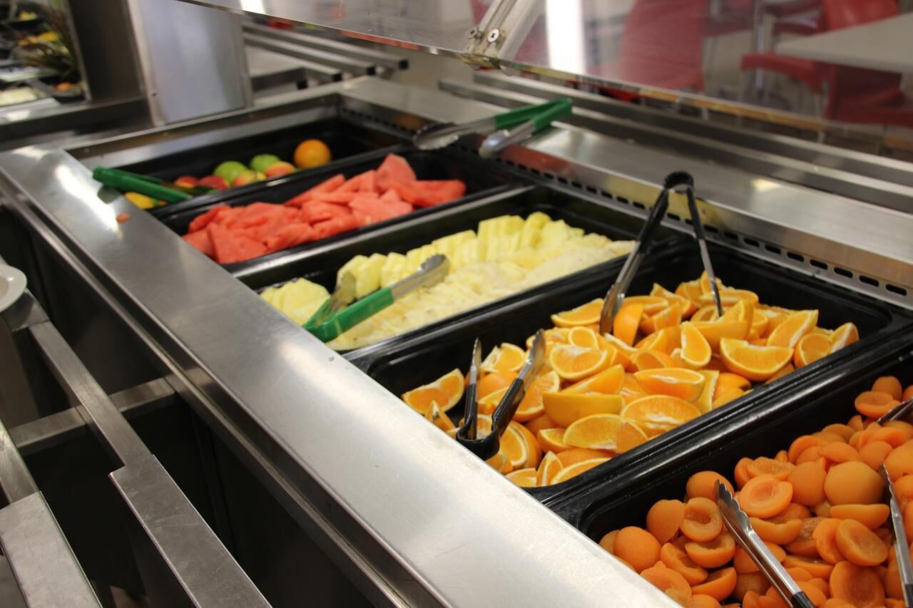 A buffet with various fruits including watermelon, pineapple, and oranges.